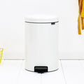 White trash bin with black foot on a white wooden floor